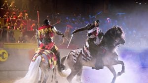 people in medieval costumes fighting on horses