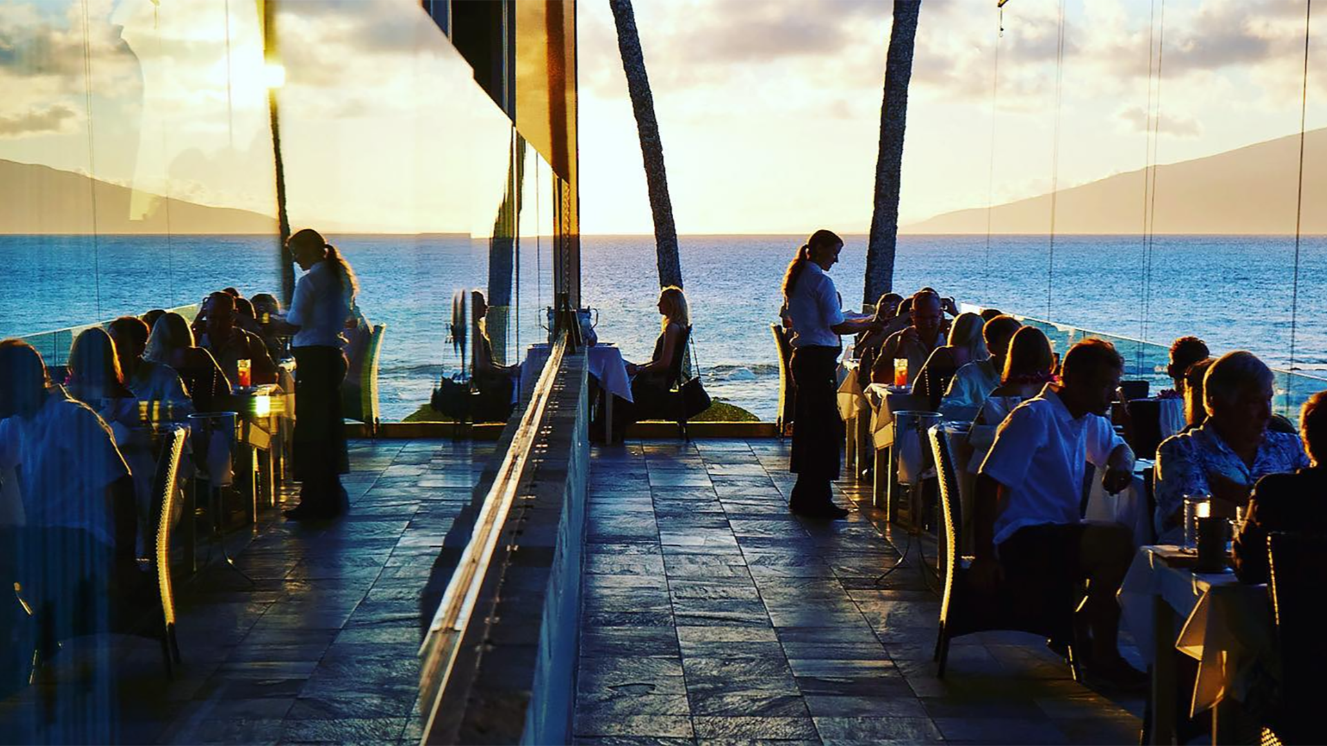 people dining in a restaurant with a view of the sea