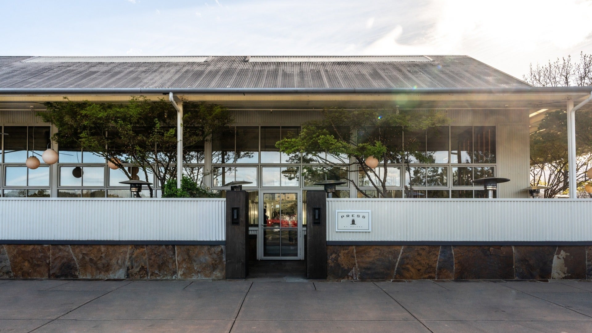 restaurant exterior with plants in front and big floor to ceiling windows