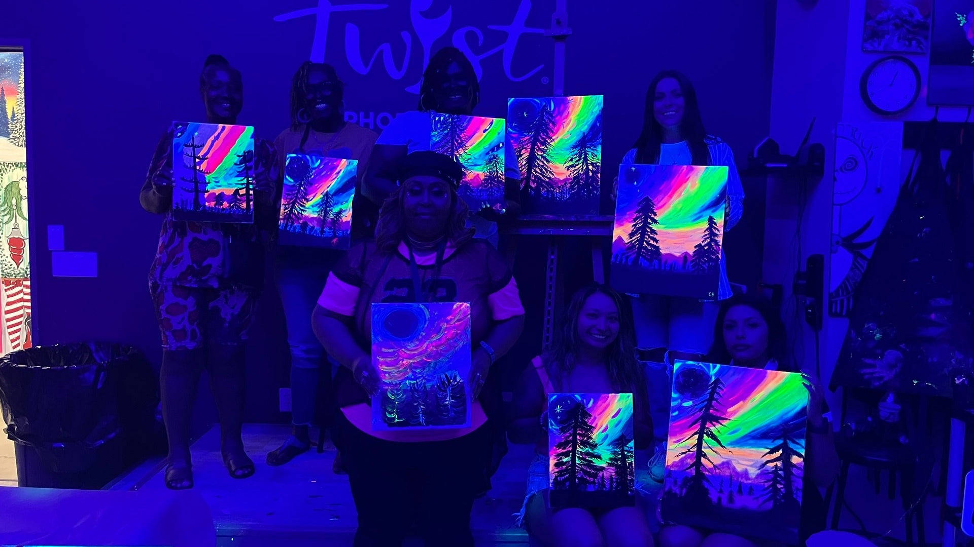 group of people with glowing paintings