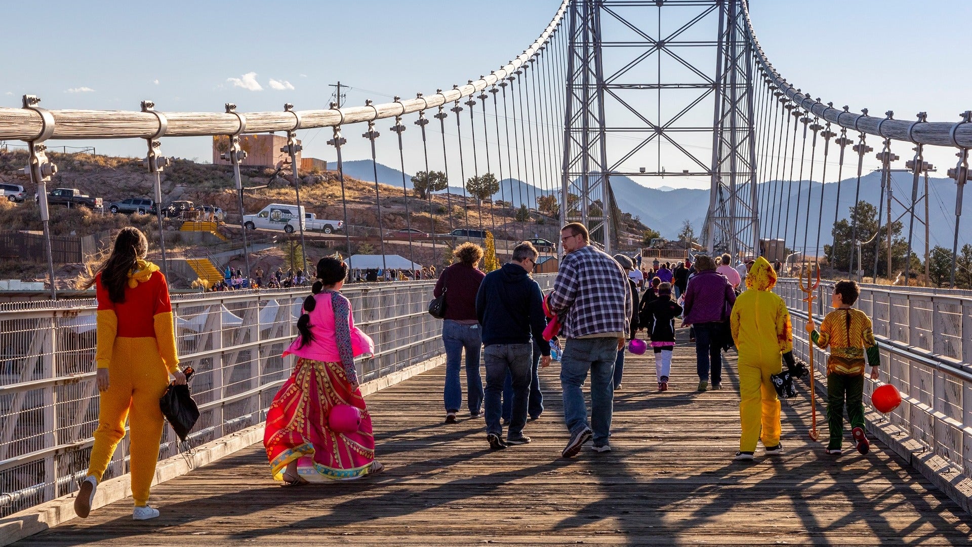 people dressed up in costumes on a suspension bridge