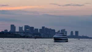 Boat on the harbor with downtown Boston in the background at sunset