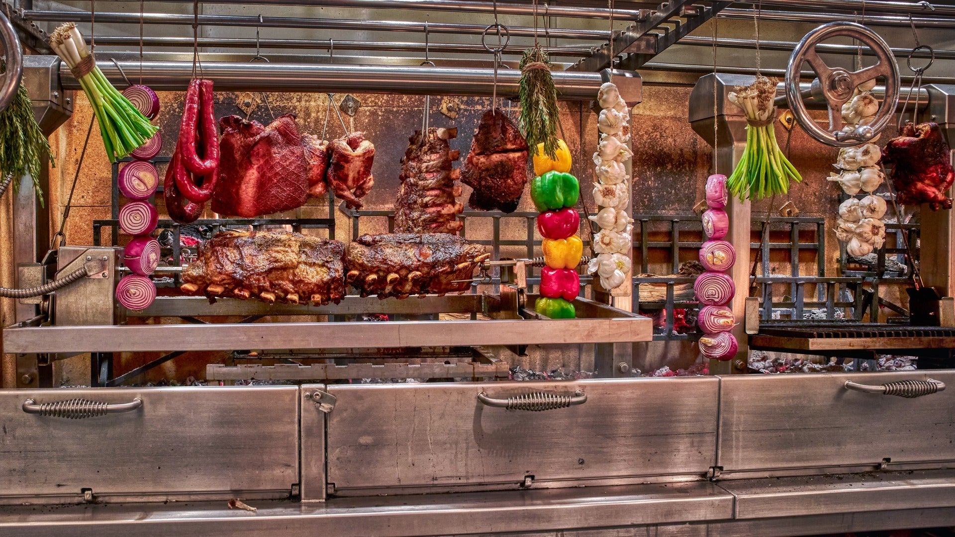 meat and various vegetables hanging in a roaster