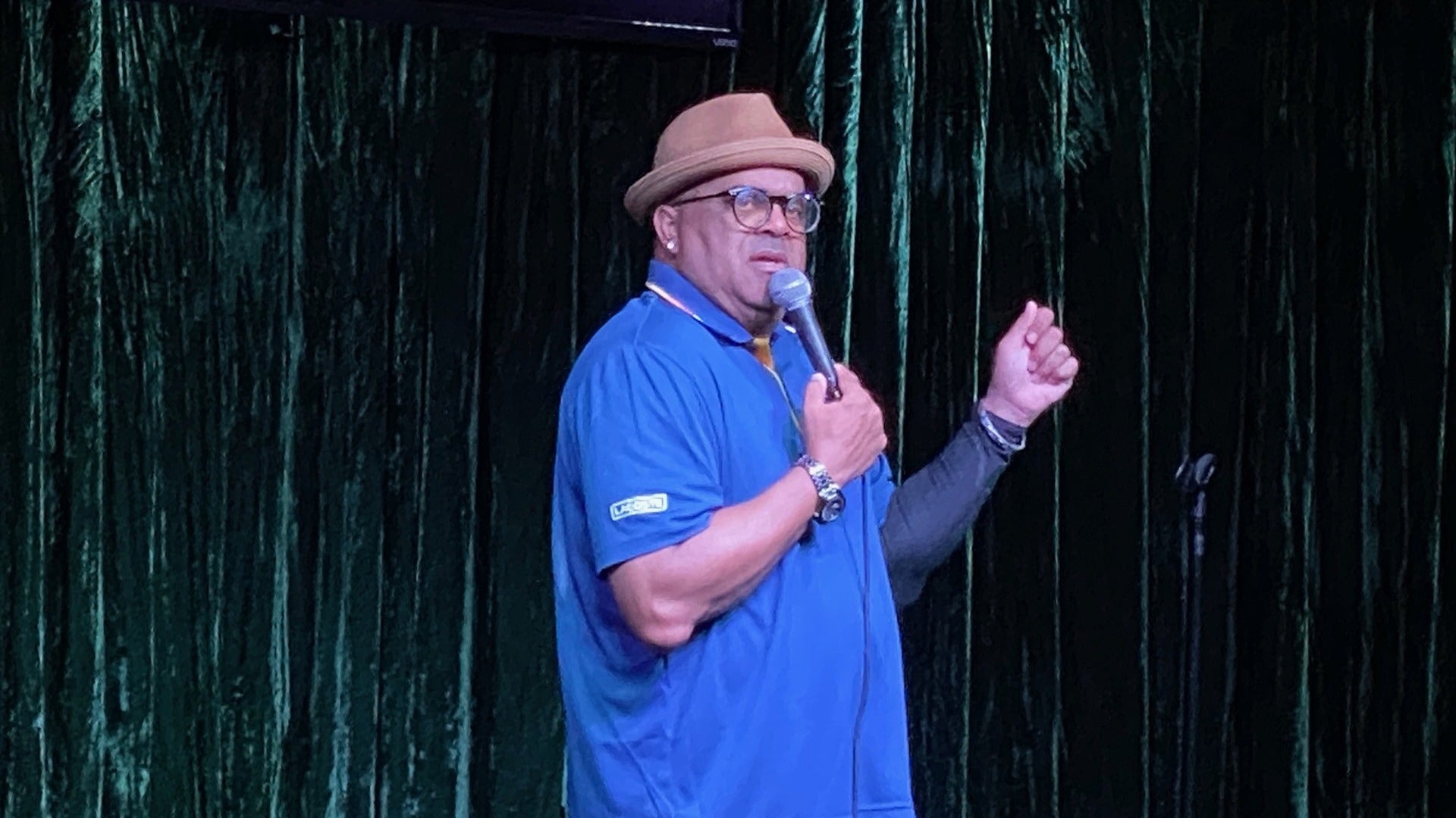 man on stage holding a mic