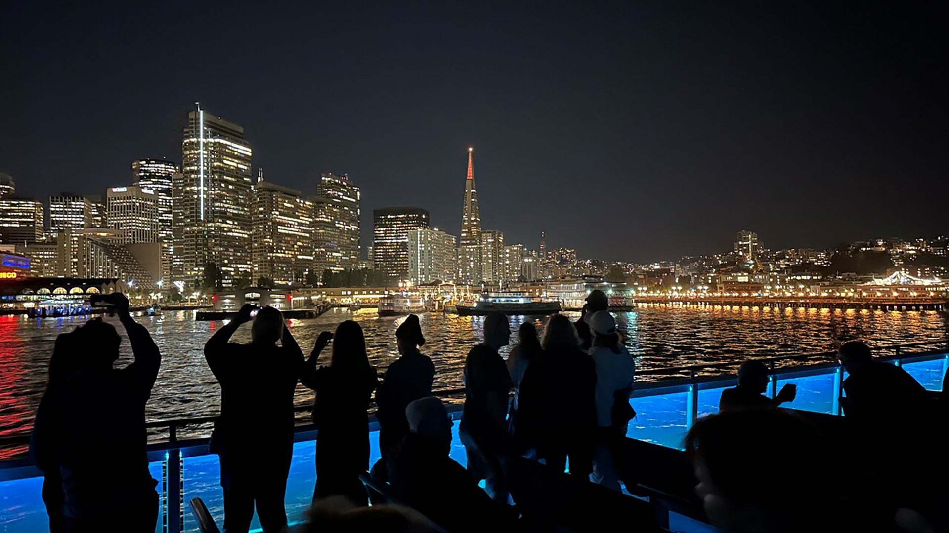 people on a cruise looking at city lights
