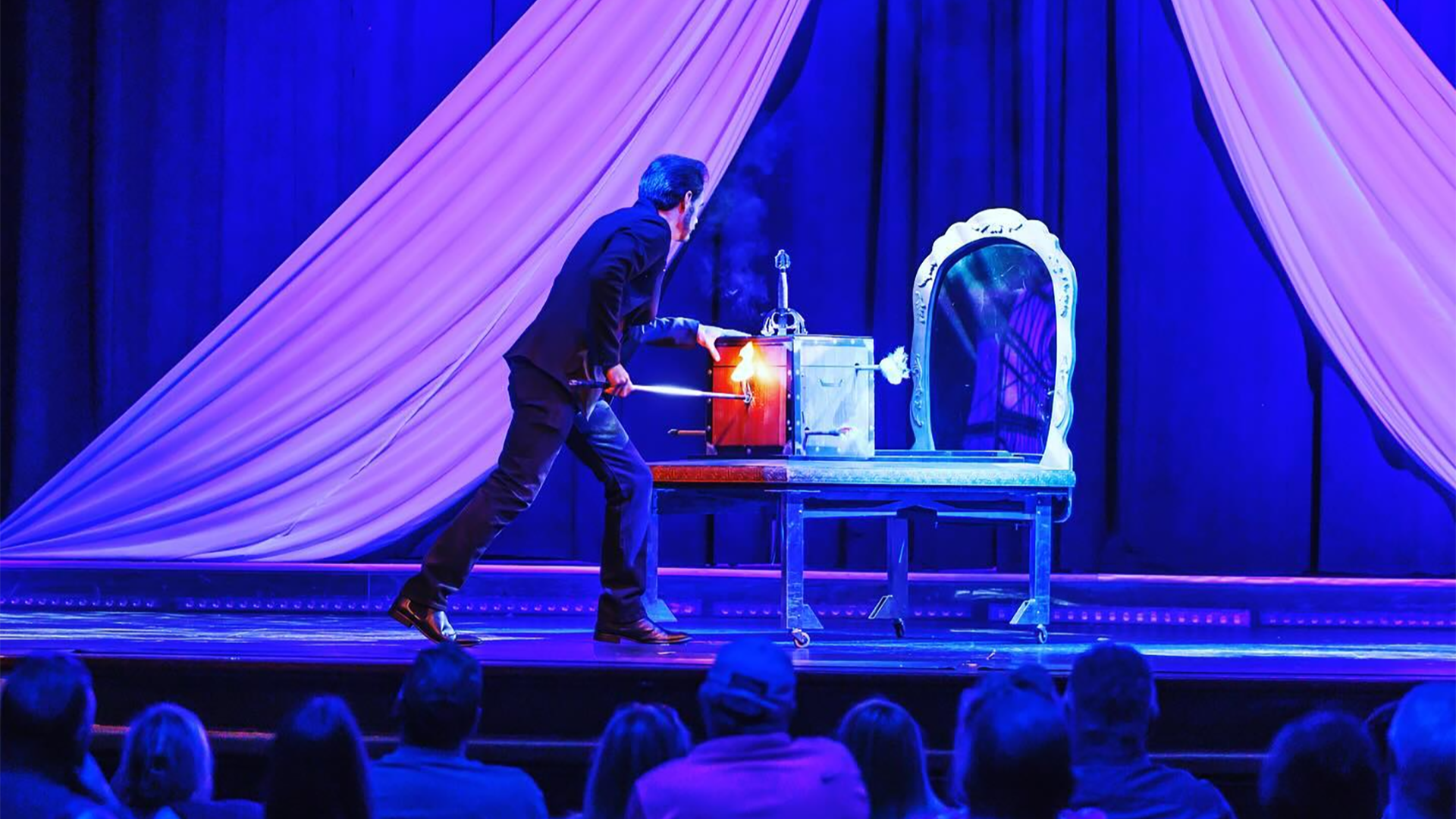 a magician performing a trick on stage