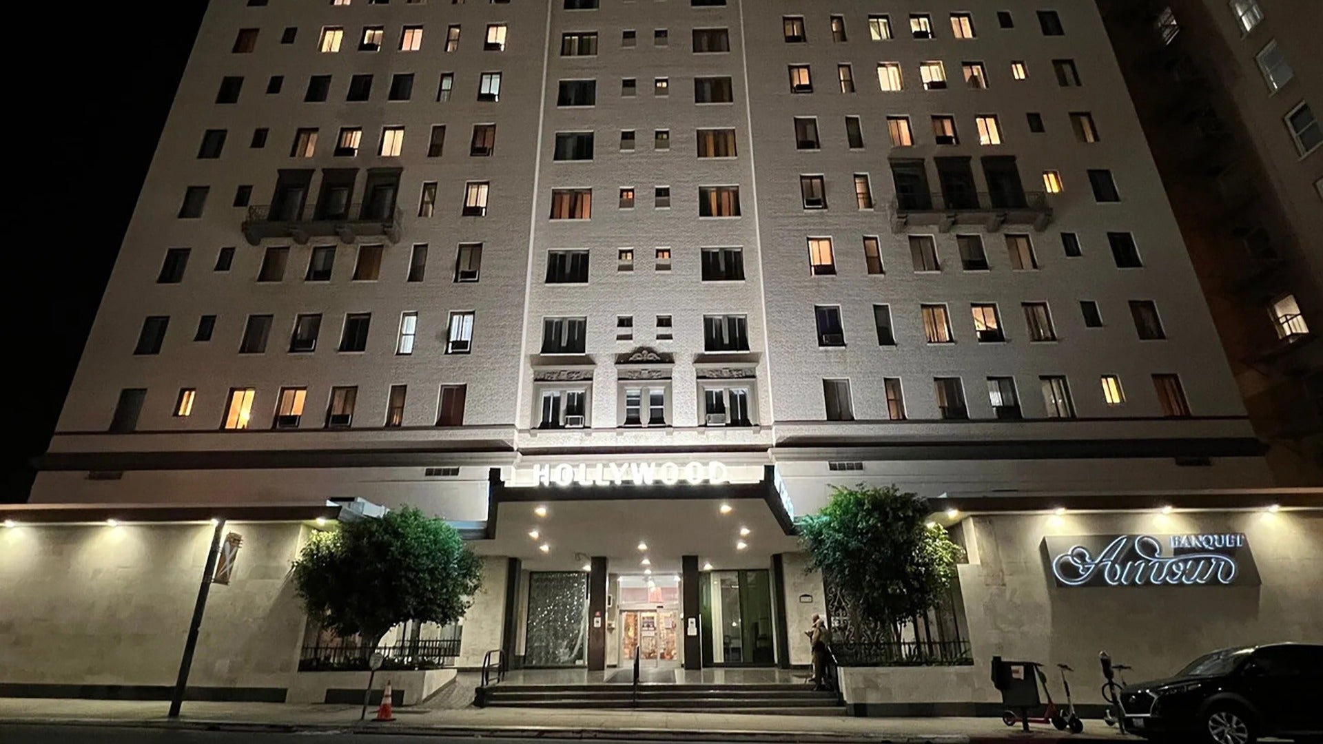 hotel exterior with trees and car in front