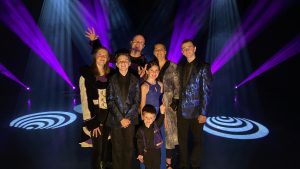 group of performers on stage with lights and in costumes