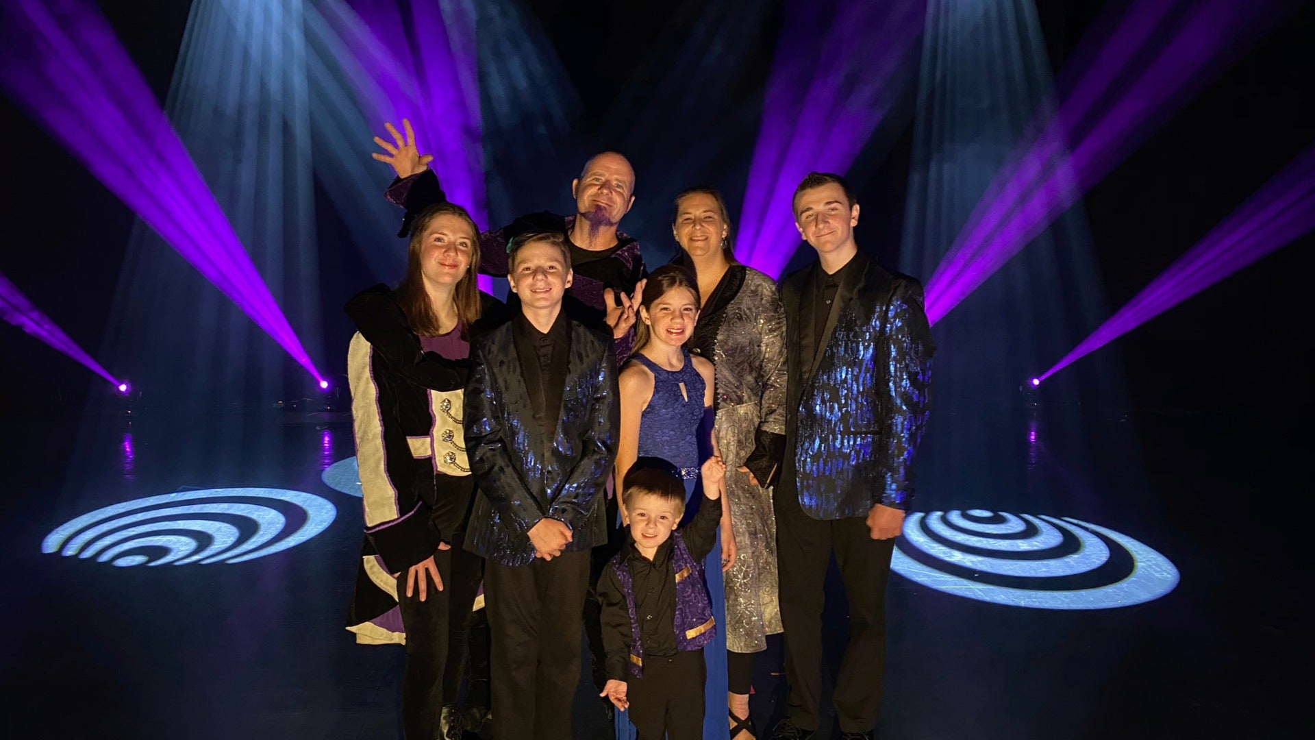 group of performers on stage with lights and in costumes