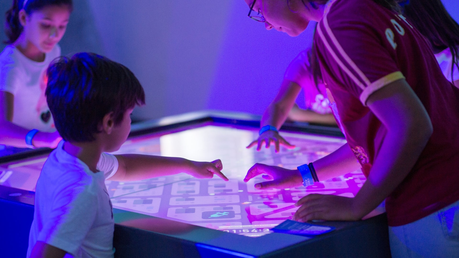 adult and children playing on a screen