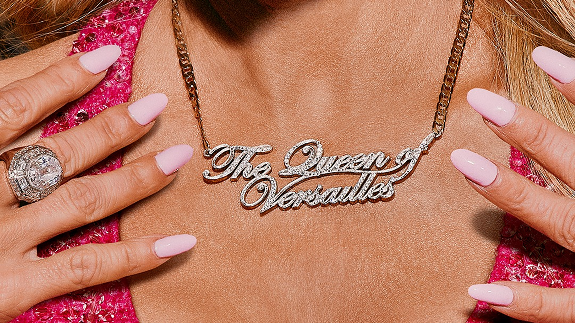 woman wearing a necklace with pink nails