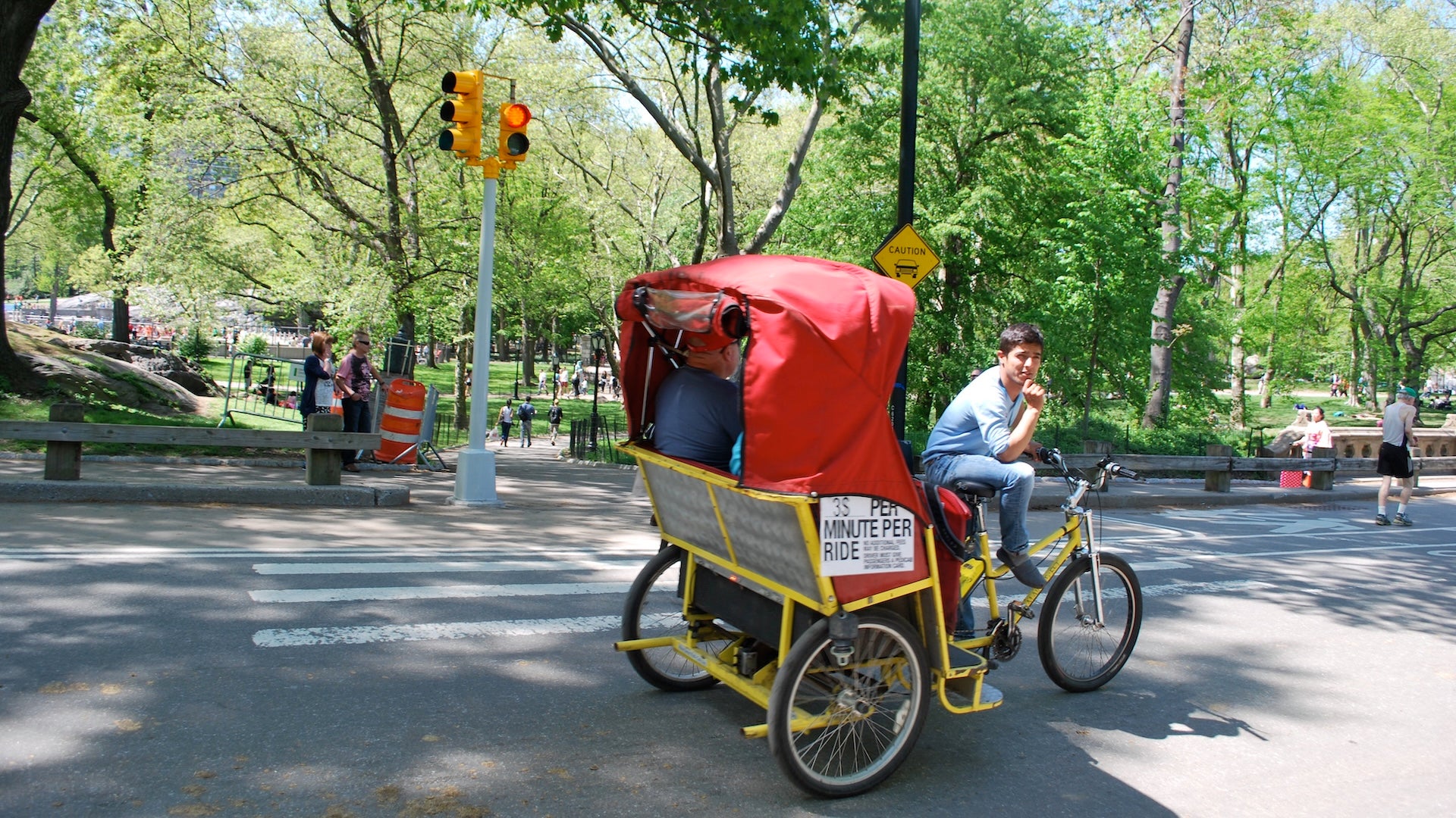 a man biking a pedicab with two passengers