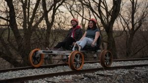 couple on a rail bike passing by the woods
