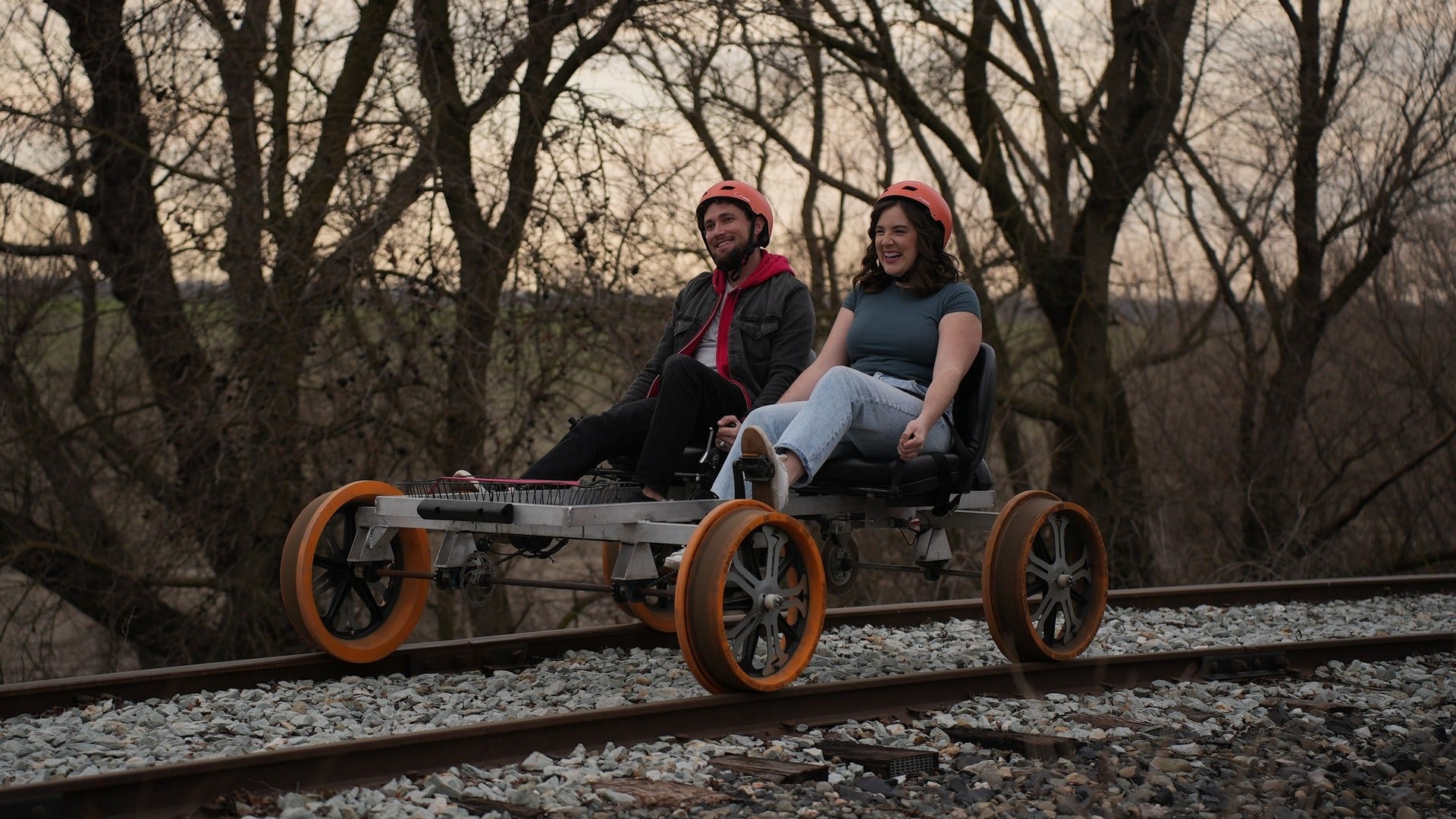 couple on a rail bike passing by the woods