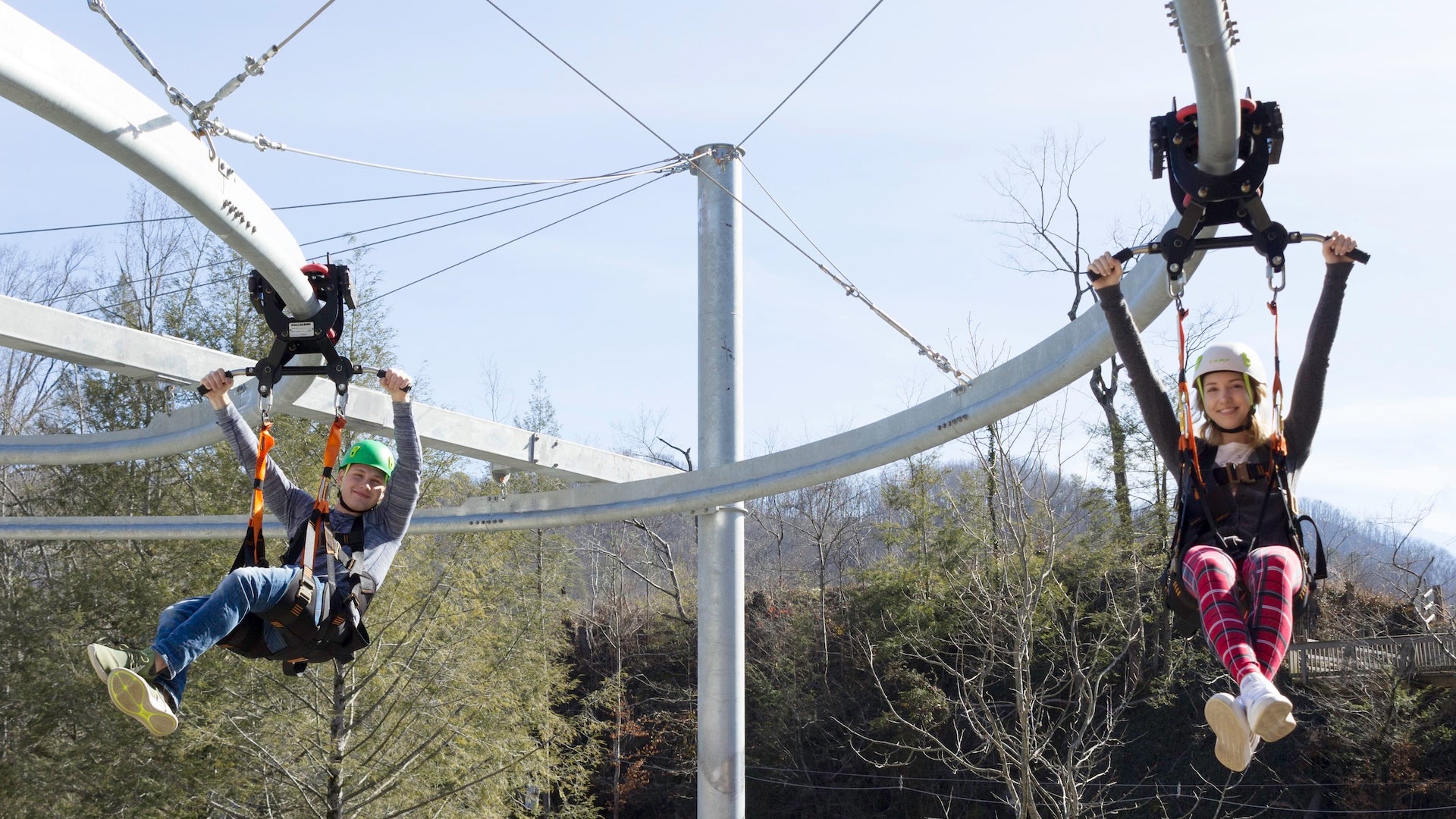 a boy and a girl riding in a zipline