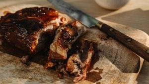 smoked ribs served on a platter with a knife on the side