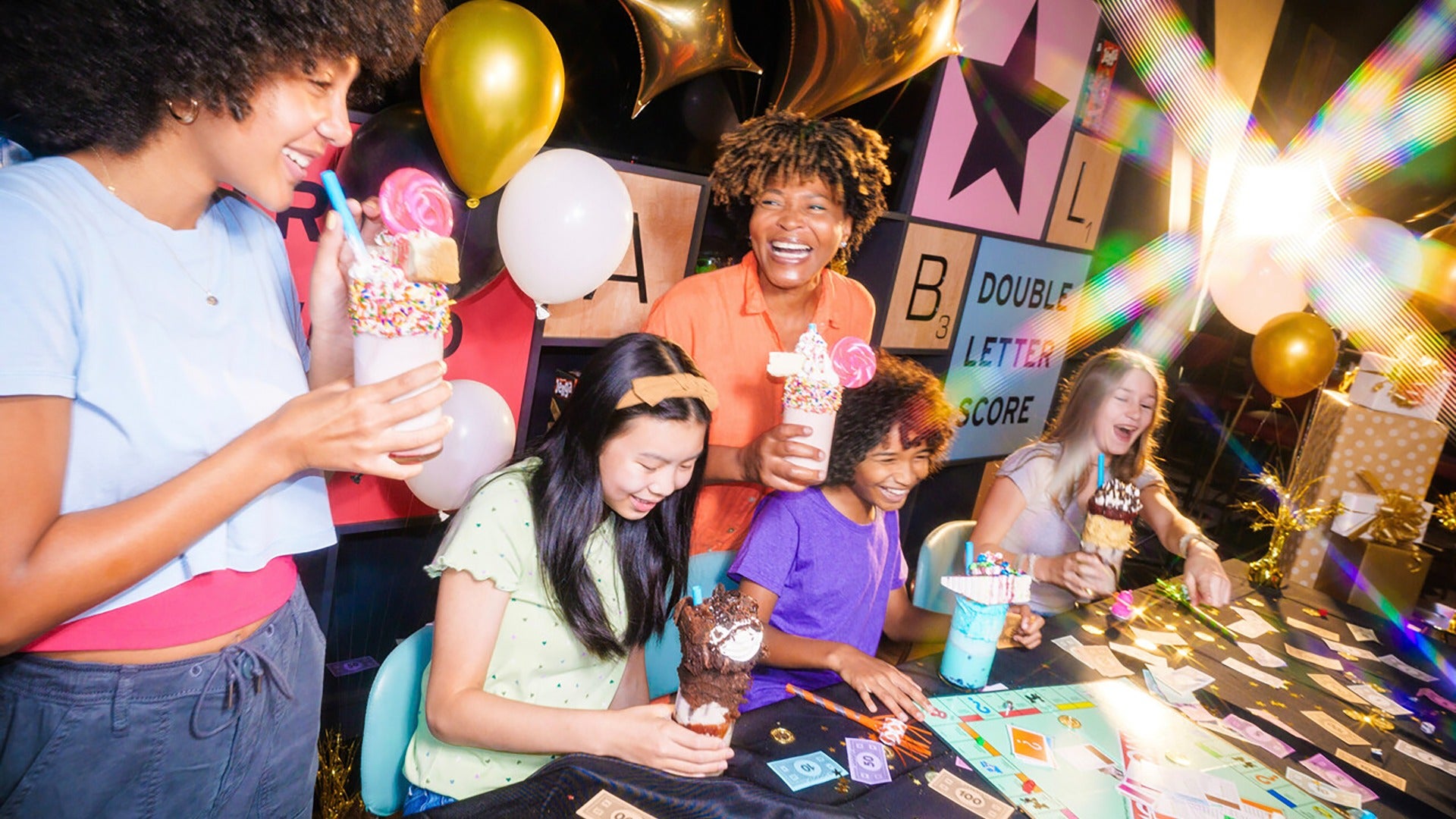 women and kids playing monopoly and enjoying milkshakes