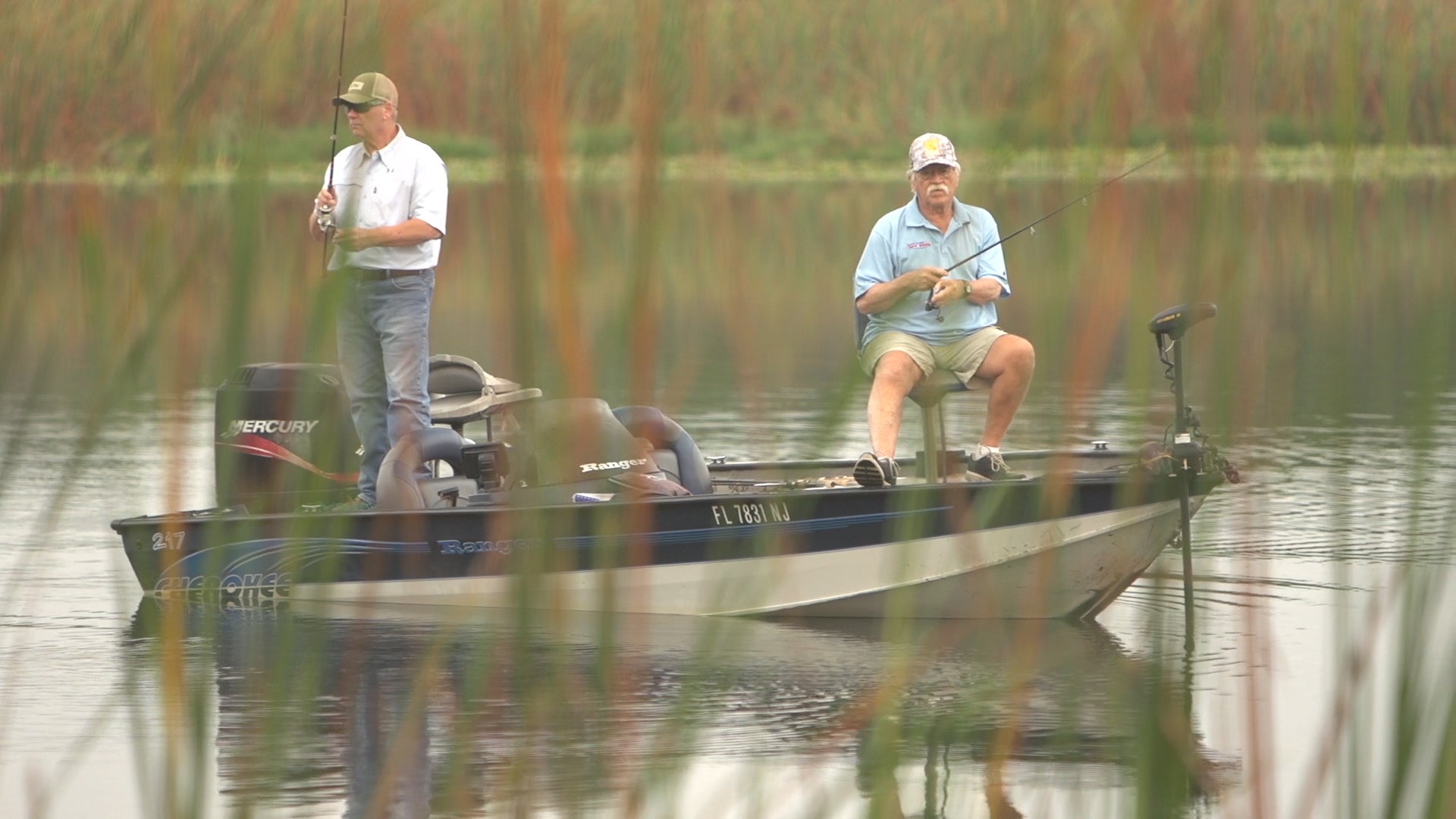 two men fishing in a small boat at a lake