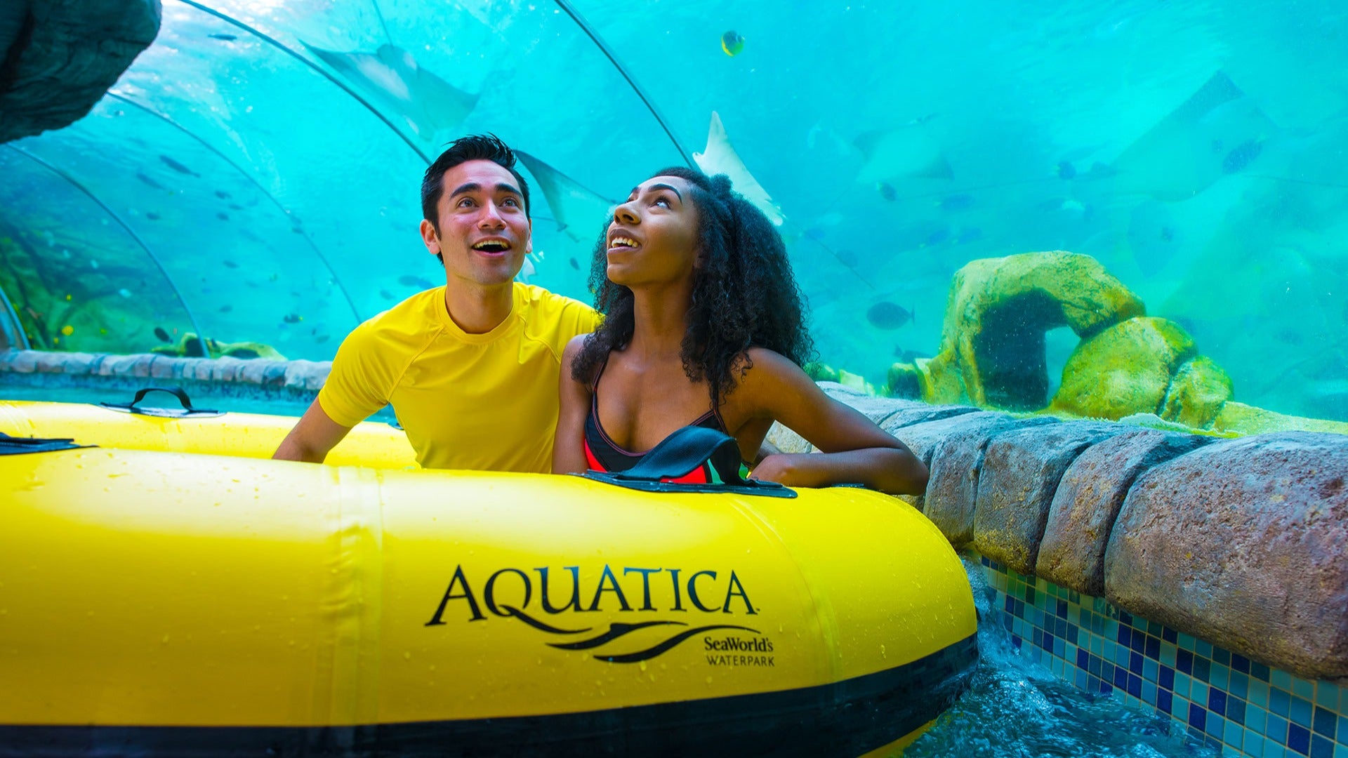 couple with yellow floatie in a water enclosure