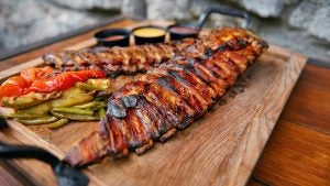 barbecued meat platter with side dishes and sauces