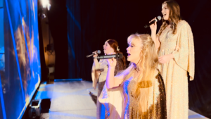 women in evening gowns singing on stage