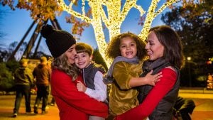 mother and children with christmas lights at the back