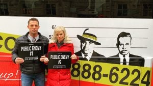 two people holding placards in a crime tour