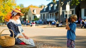 kid taking a photo of a woman in costume
