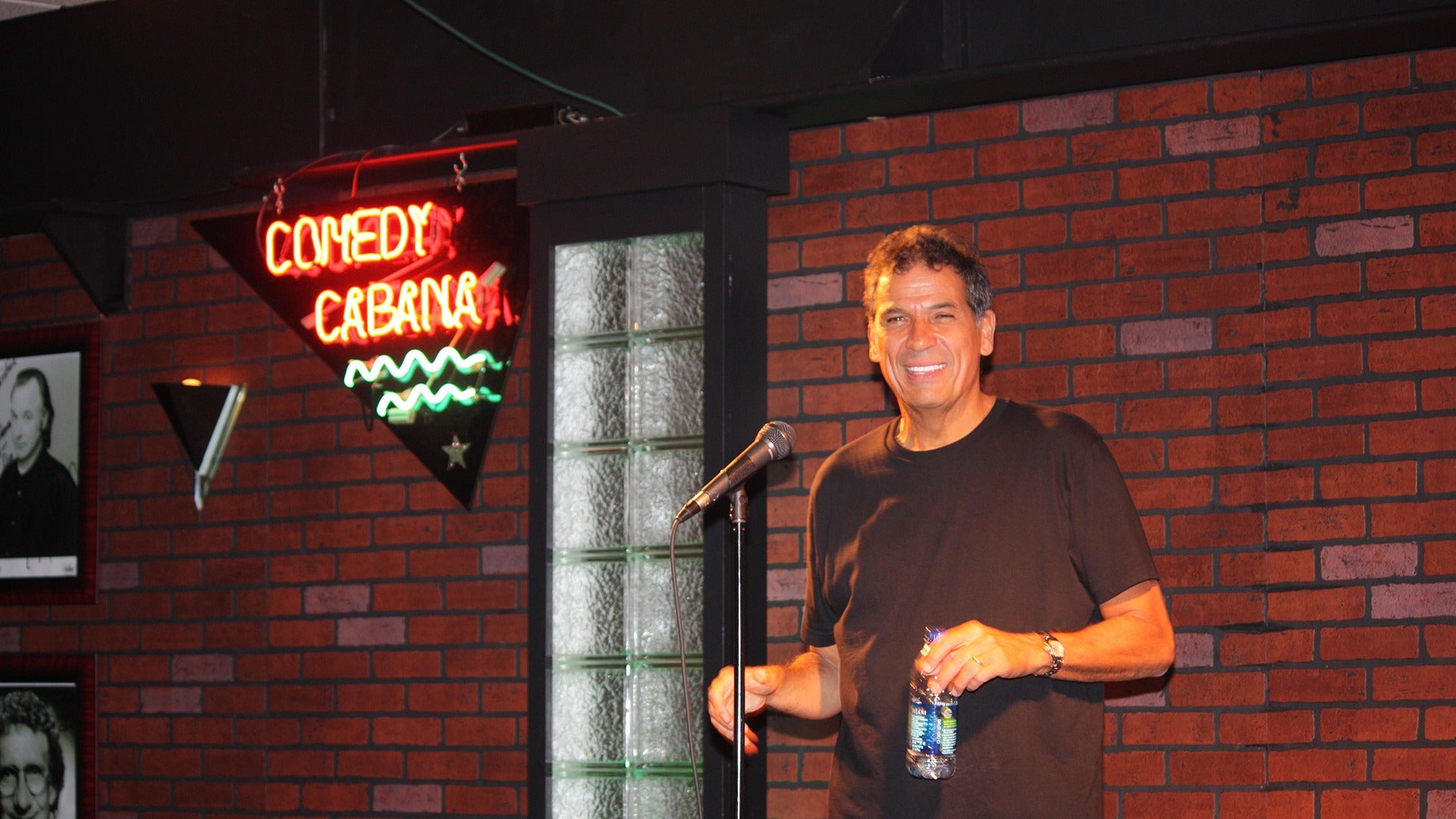 a man on stage holding a water bottle
