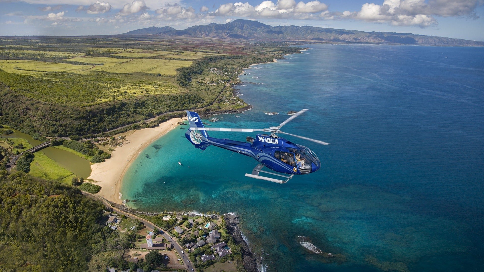helicopter touring an island and flying over the ocean