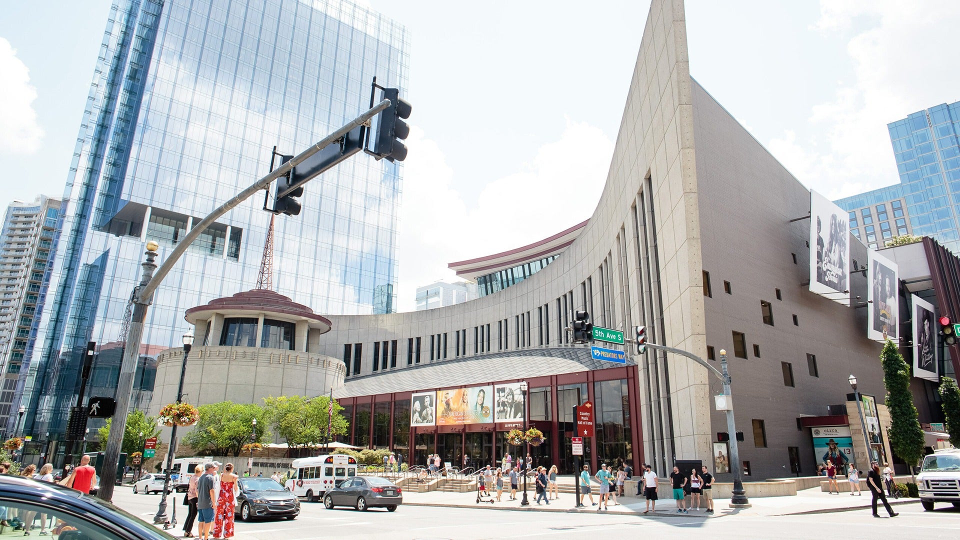 a building with people walking around it and cars passing by