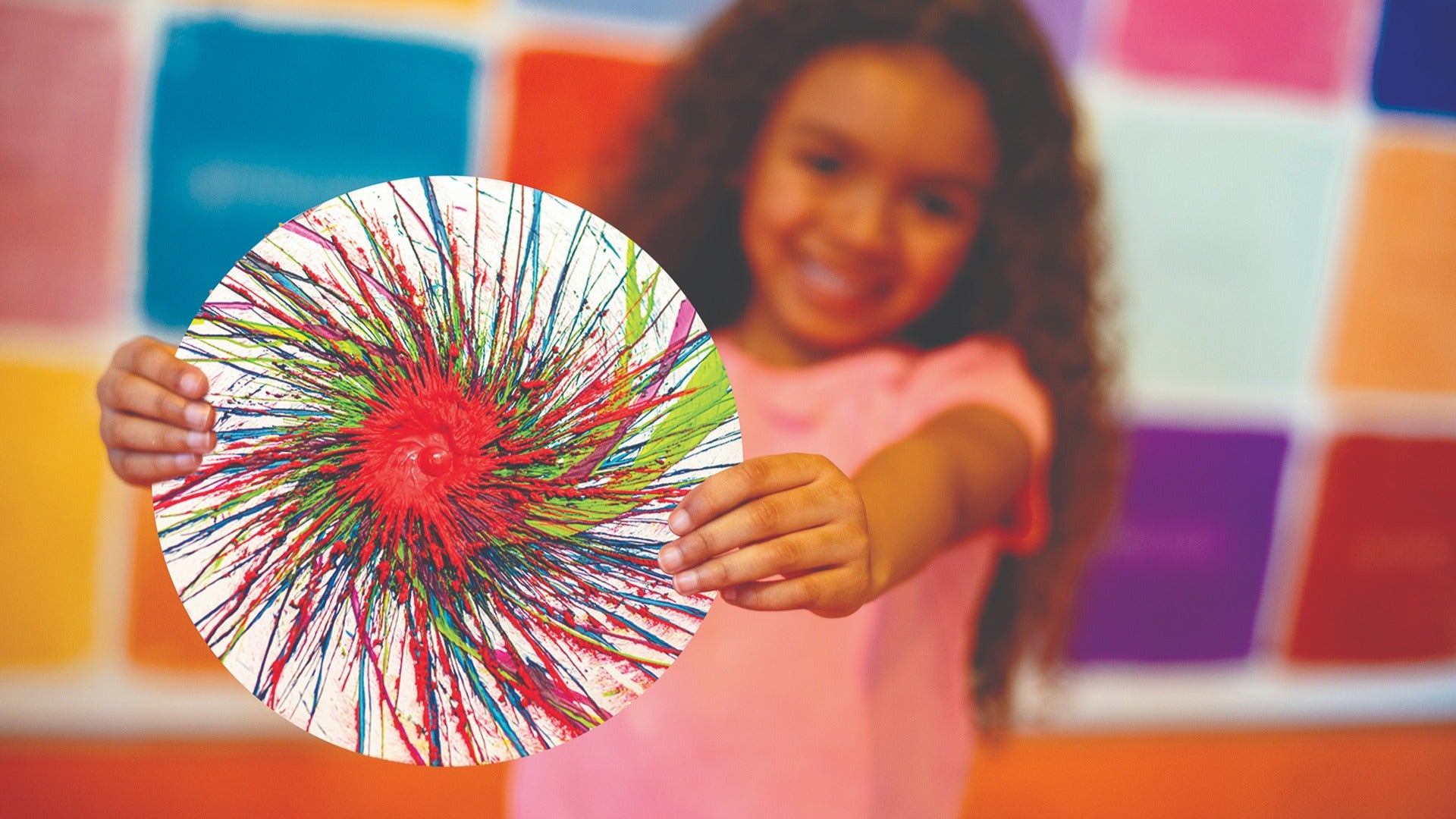 a kid holding an artwork made of crayons