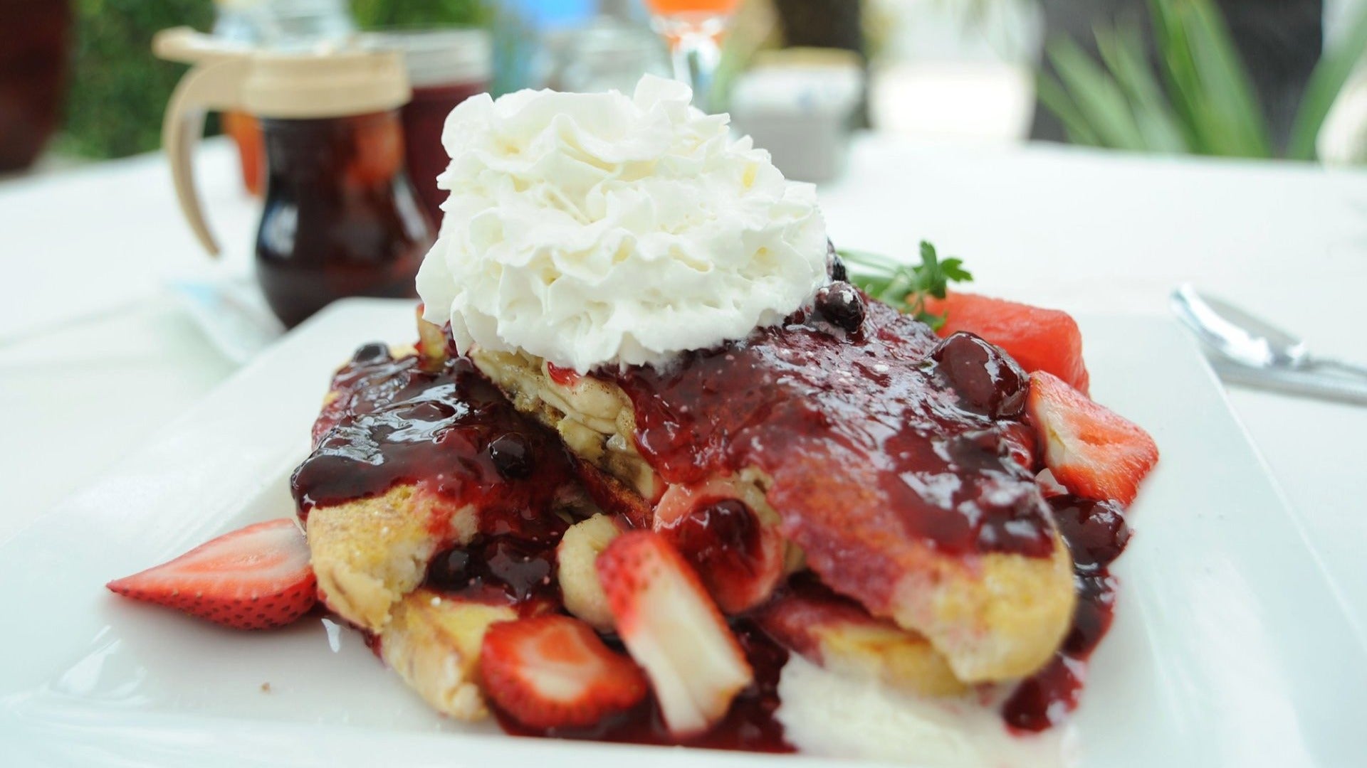french toast with whipped cream and jam and fresh strawberries