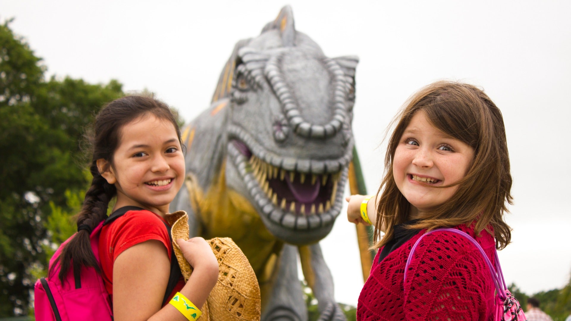 girls with a dinosaur statue at the back