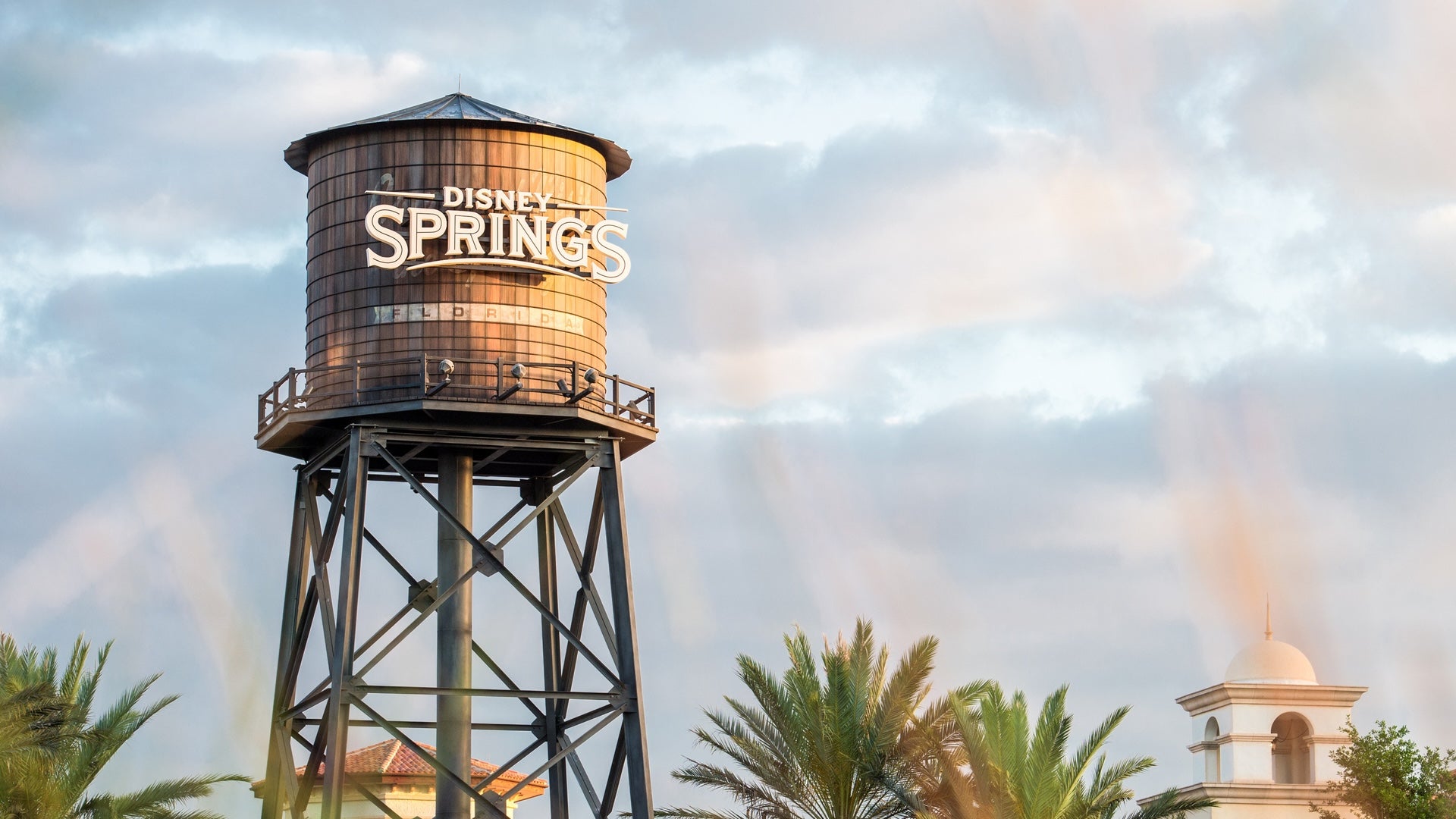 Water tower with Disney Springs on it under a cloudy sky