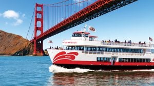 cruise boat with passengers and a view of the golden gate bridge at the back