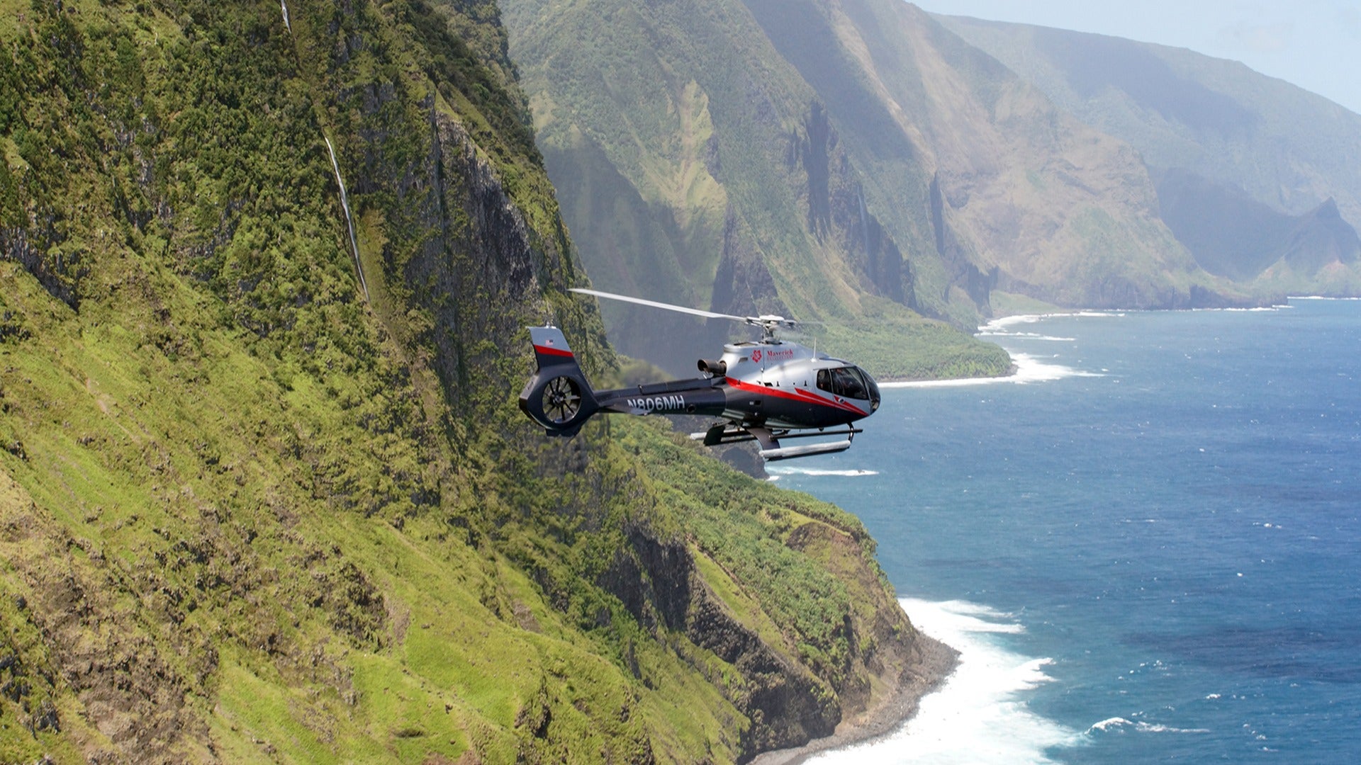 helicopter flying over a rainforest and the ocean