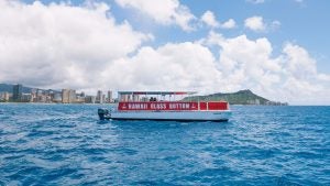 a boat on the ocean with a view of the city at the back
