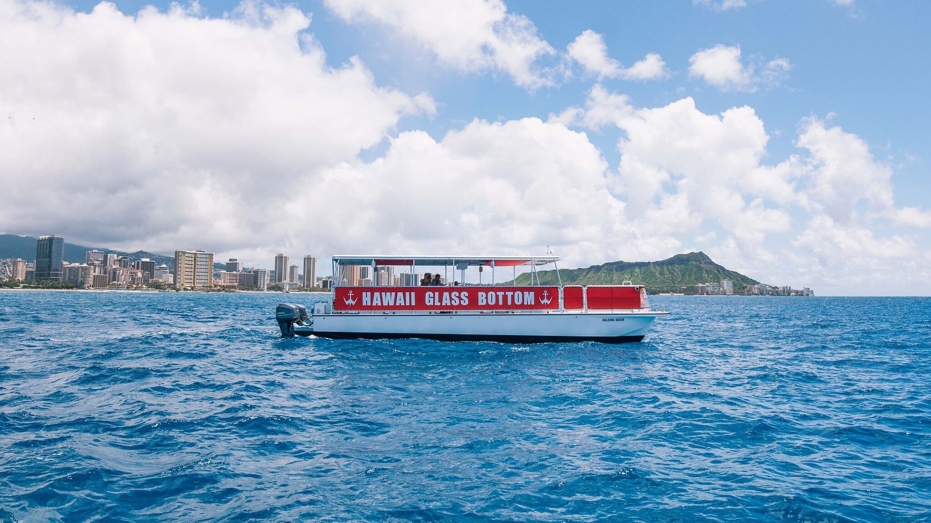 a boat on the ocean with a view of the city at the back