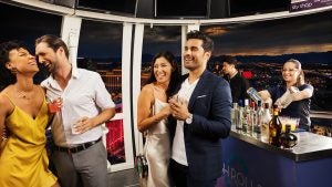 couples having fun and toasting drinks with an alcohol bar behind