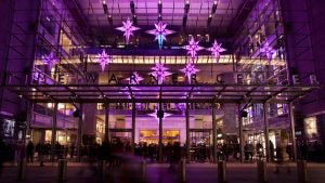 building with lights display and people passing by