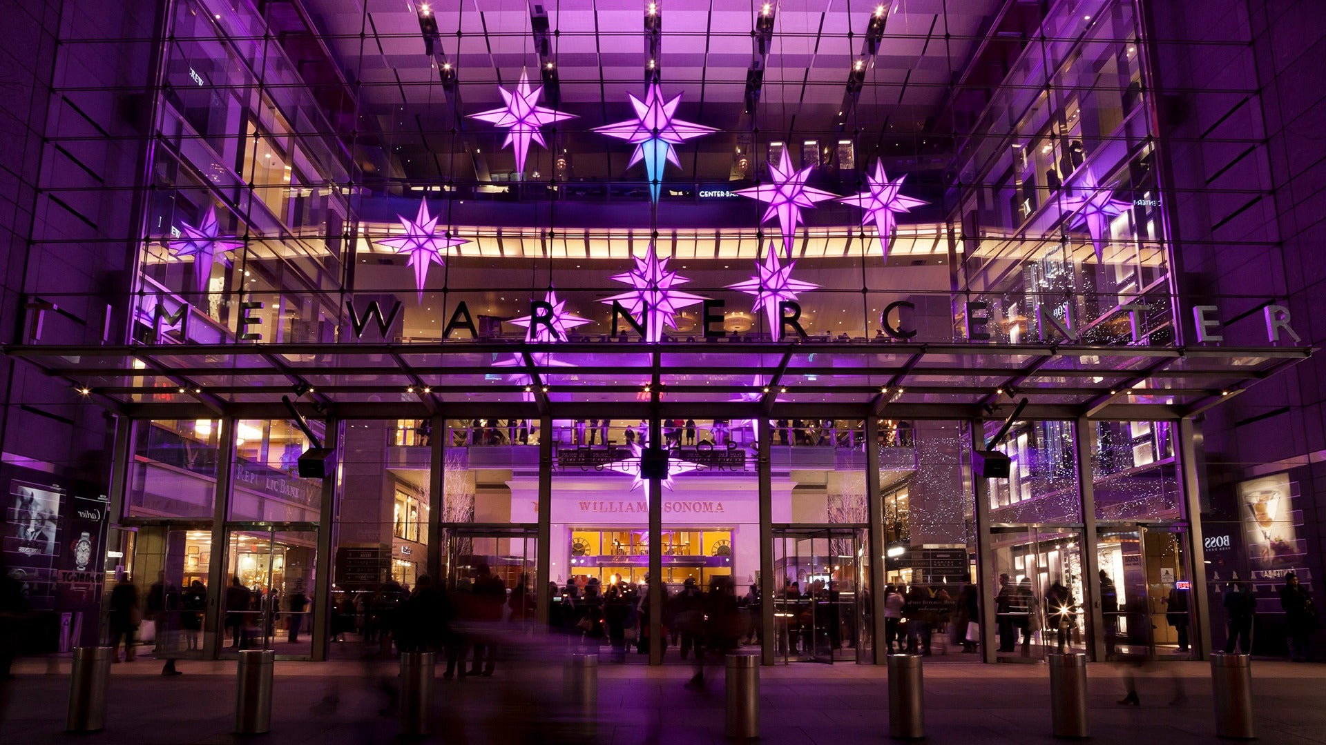 building with lights display and people passing by