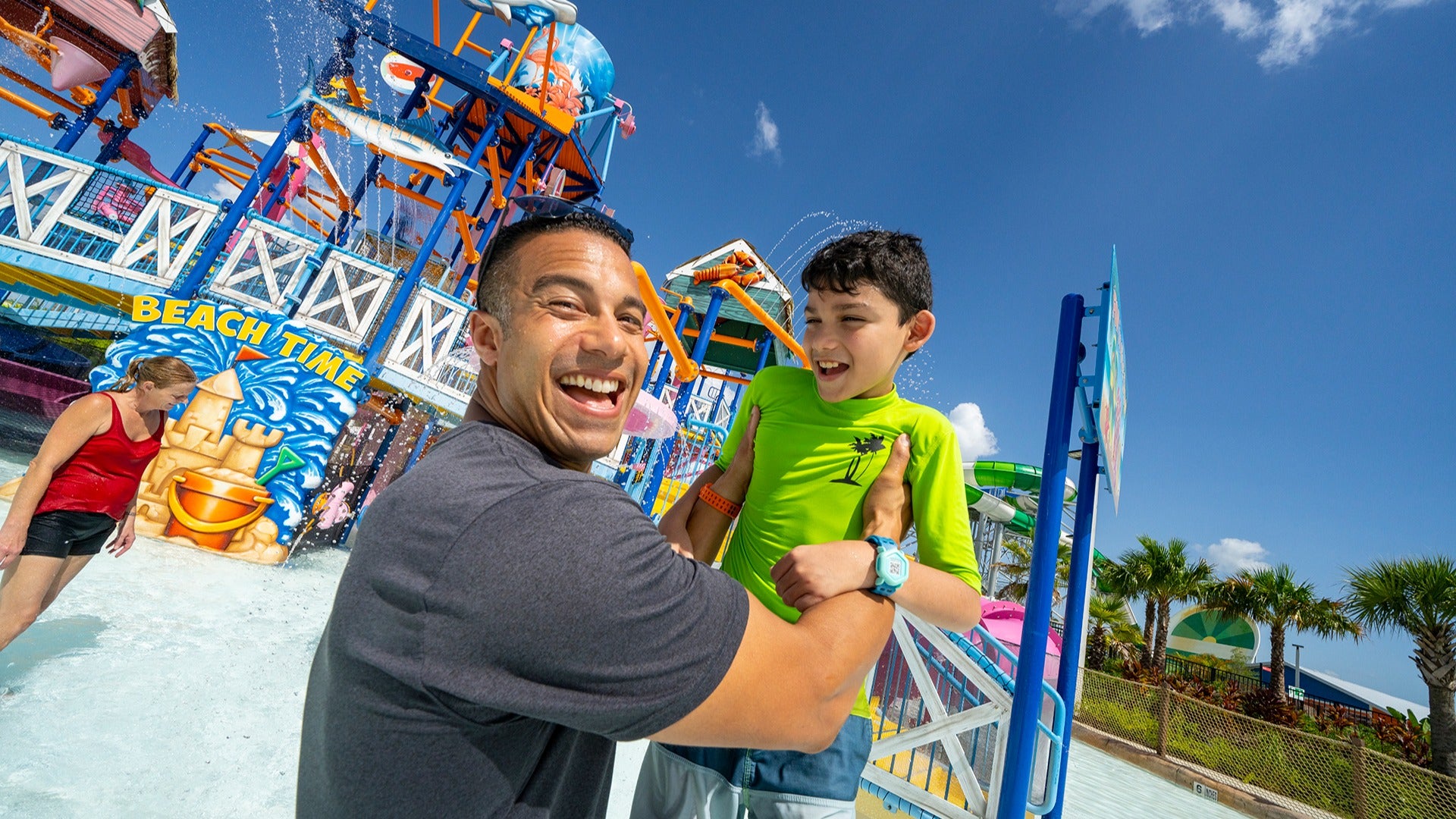 father holding his son up in a waterpark