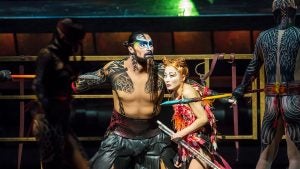 stage actors in costume holding spears and weapons