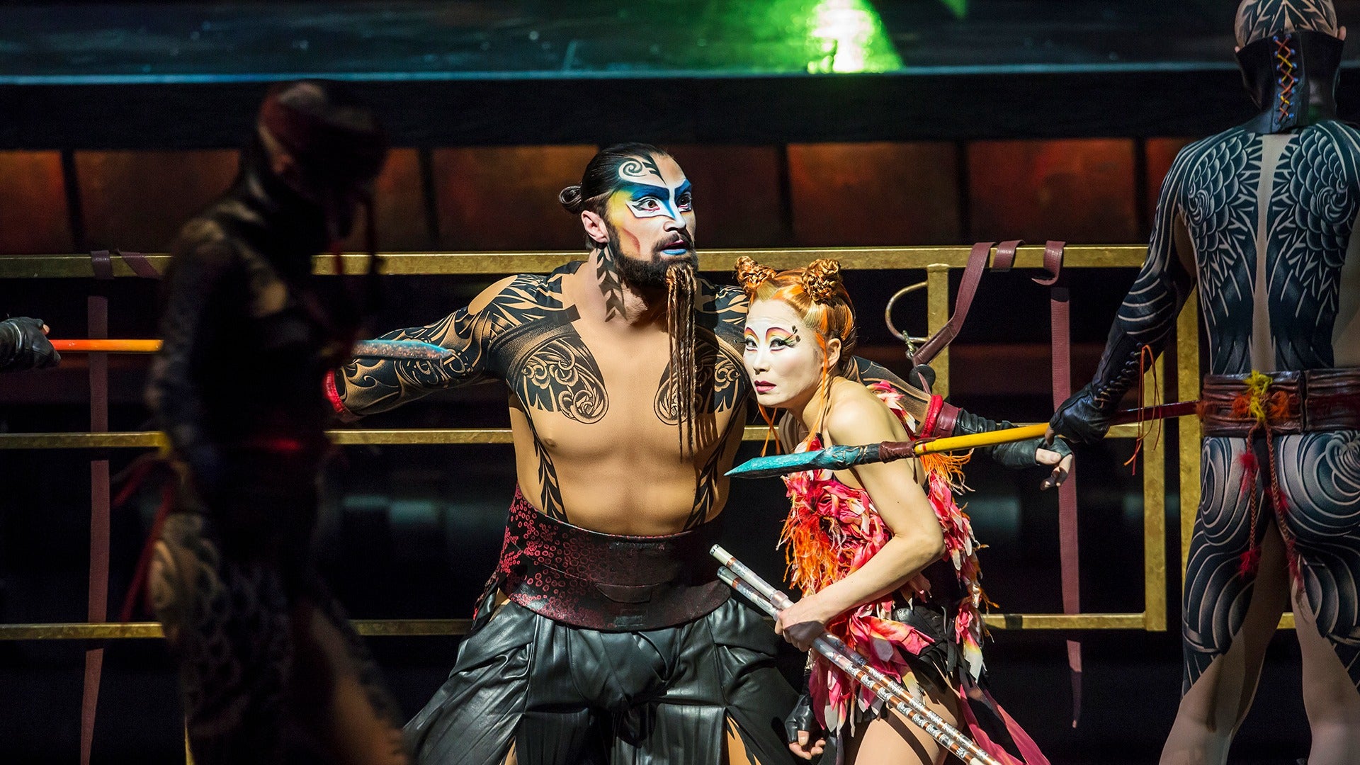 stage actors in costume holding spears and weapons