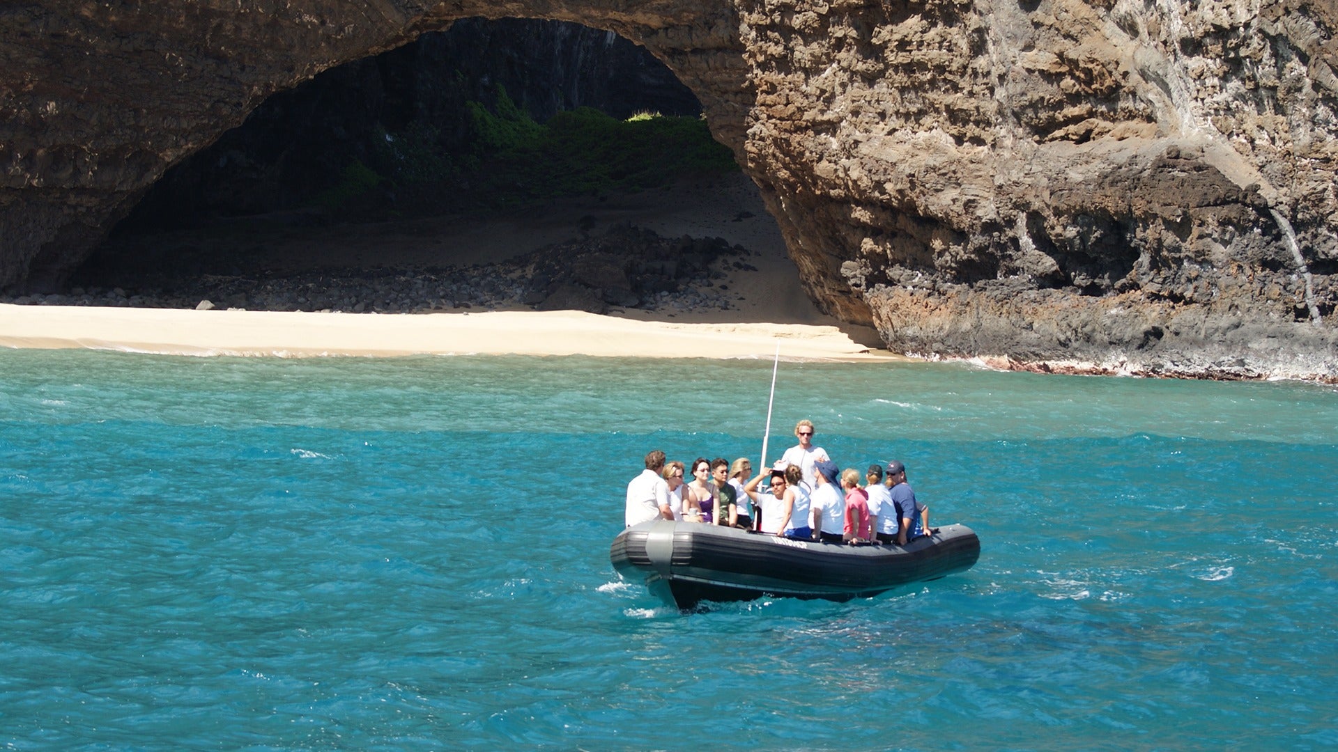 people on a boat with a view of the beach cave