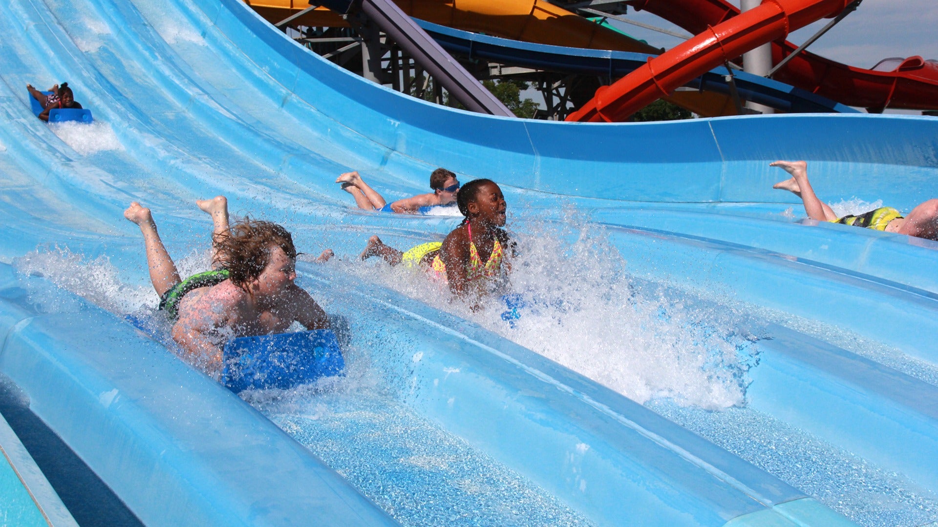 children going down slides at a waterpark