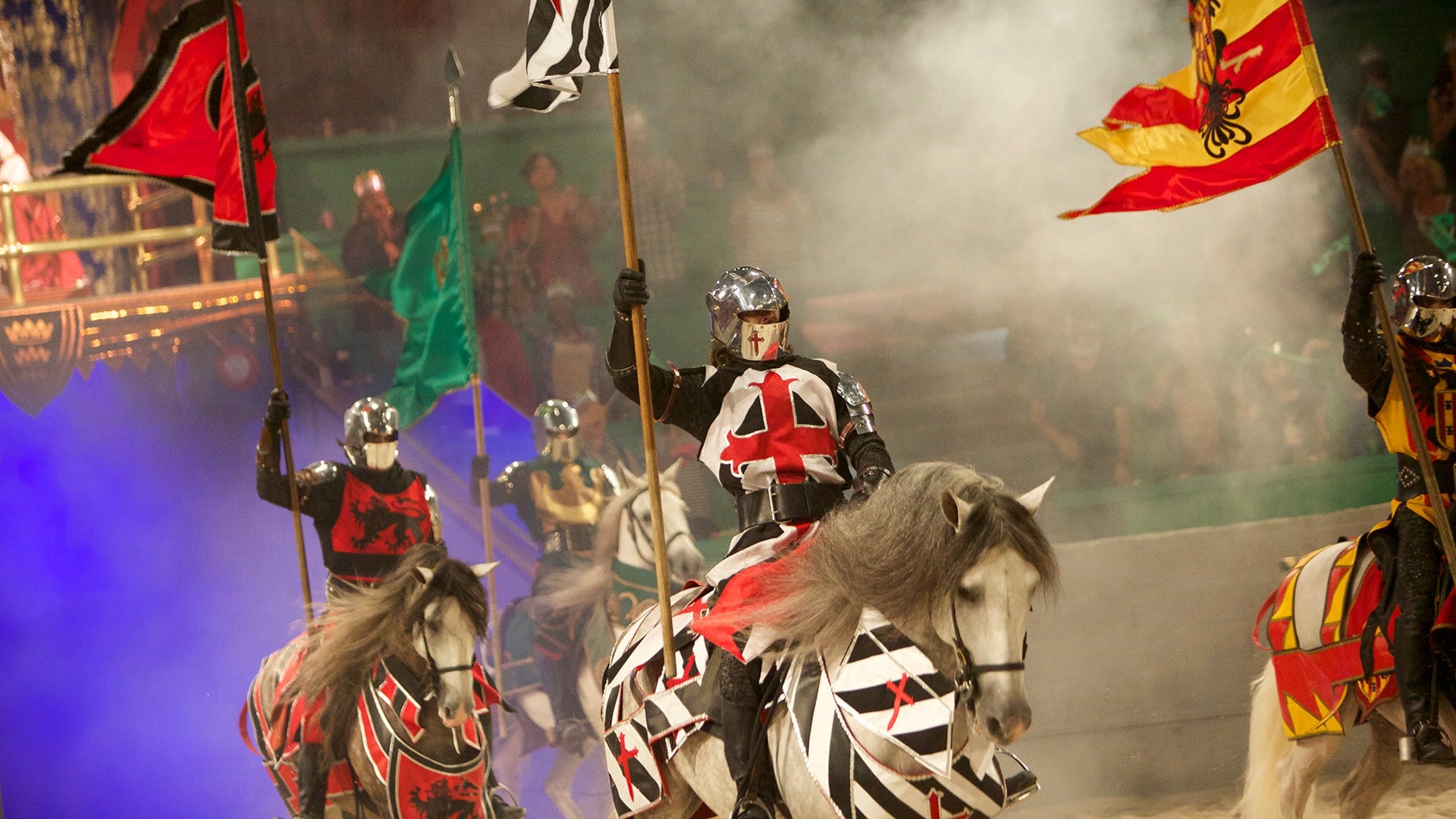 knights in costume bearing flags and riding horses
