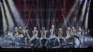 group of performers dancing on stage in costumes
