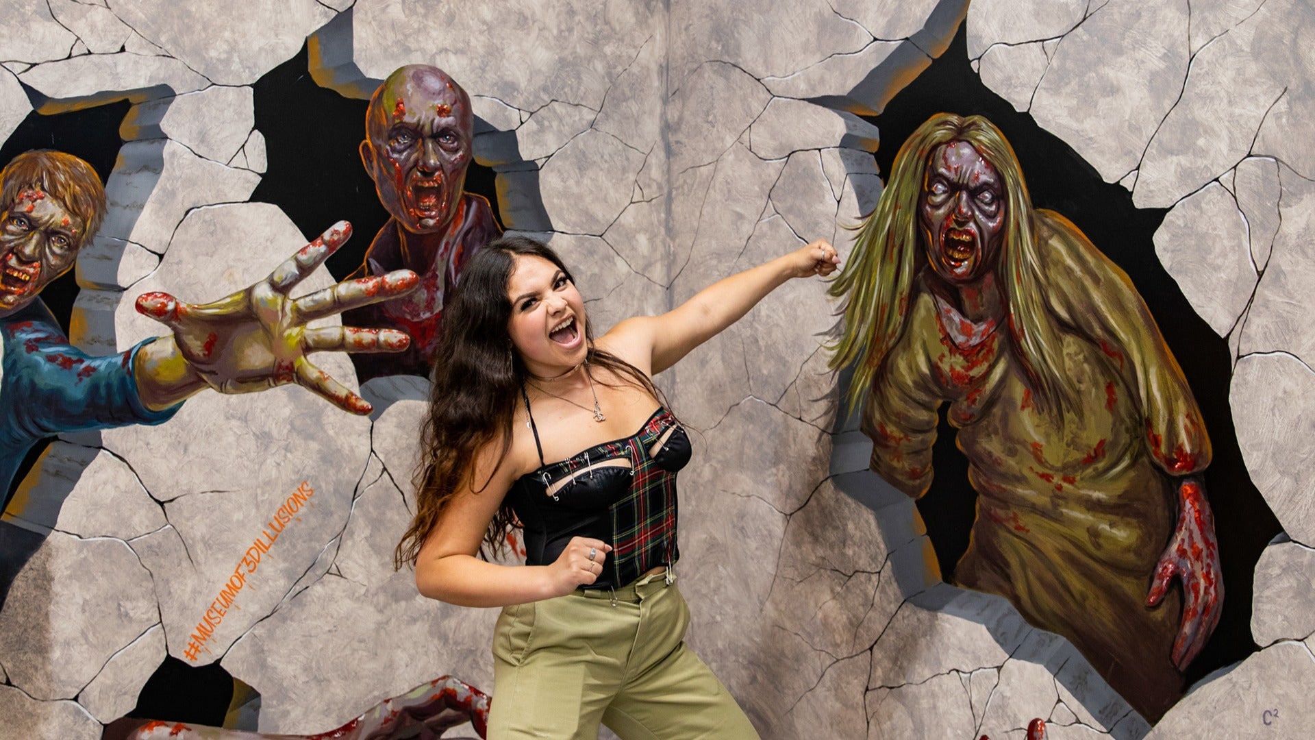 woman in an illusion museum pretending to fight zombies